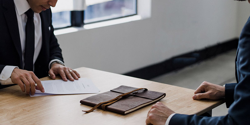 two people across a desk having business support